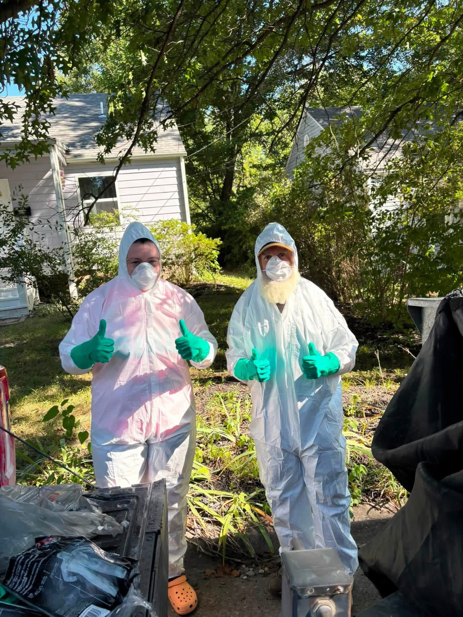 The two-person Missouri Junkers crew in protective suits at a property cleanout