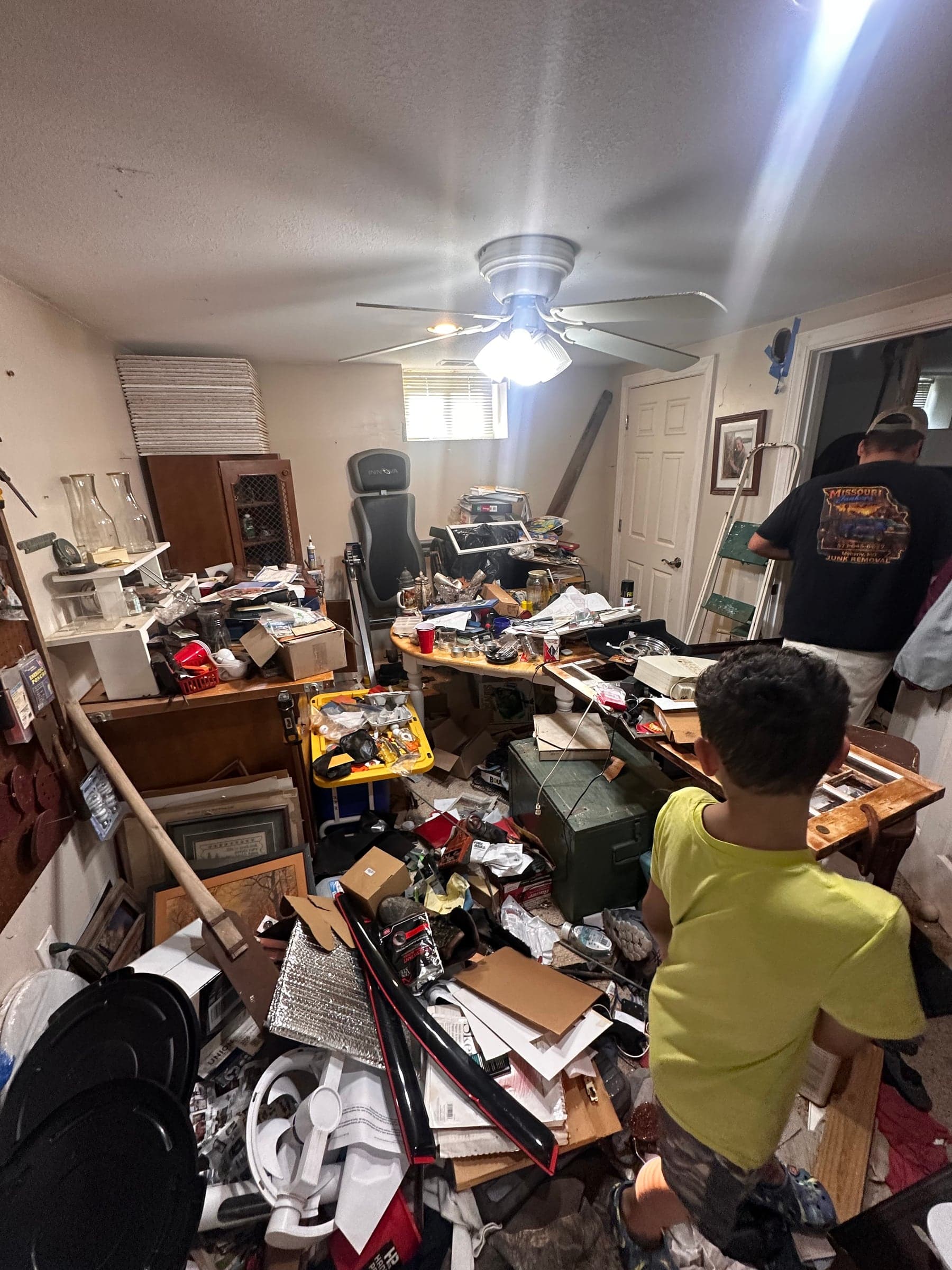A cluttered room mid-cleanout, boxes and papers being sorted